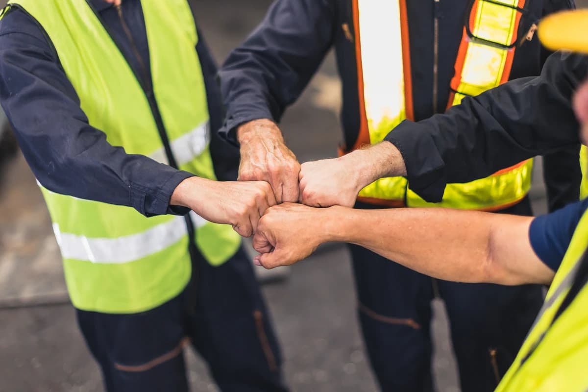 Volunteers working side by side on a community project, gathered around a shared task.